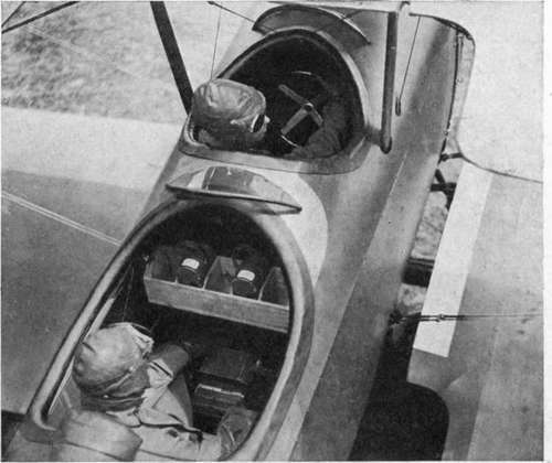 Training plane equipped for photography, showing L camera in floor mount and magazine rack forward of the observer.